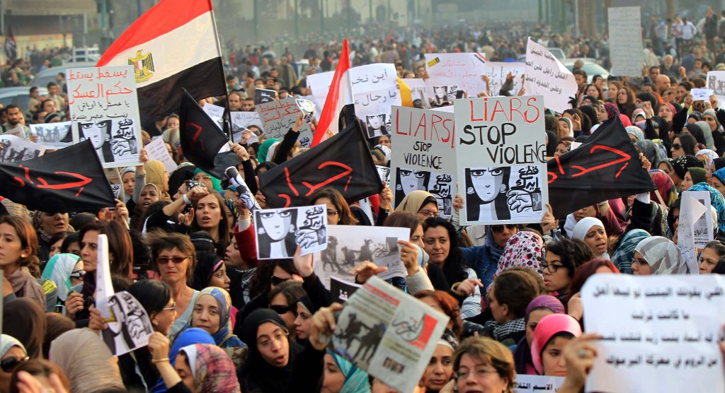 Egyptians hold signs during a protest in downtown Cairo to denounce the military's attacks on women and to call for an immediate end to the violence against protesters on December 20, 2011. AFP PHOTO/KHALED DESOUKI